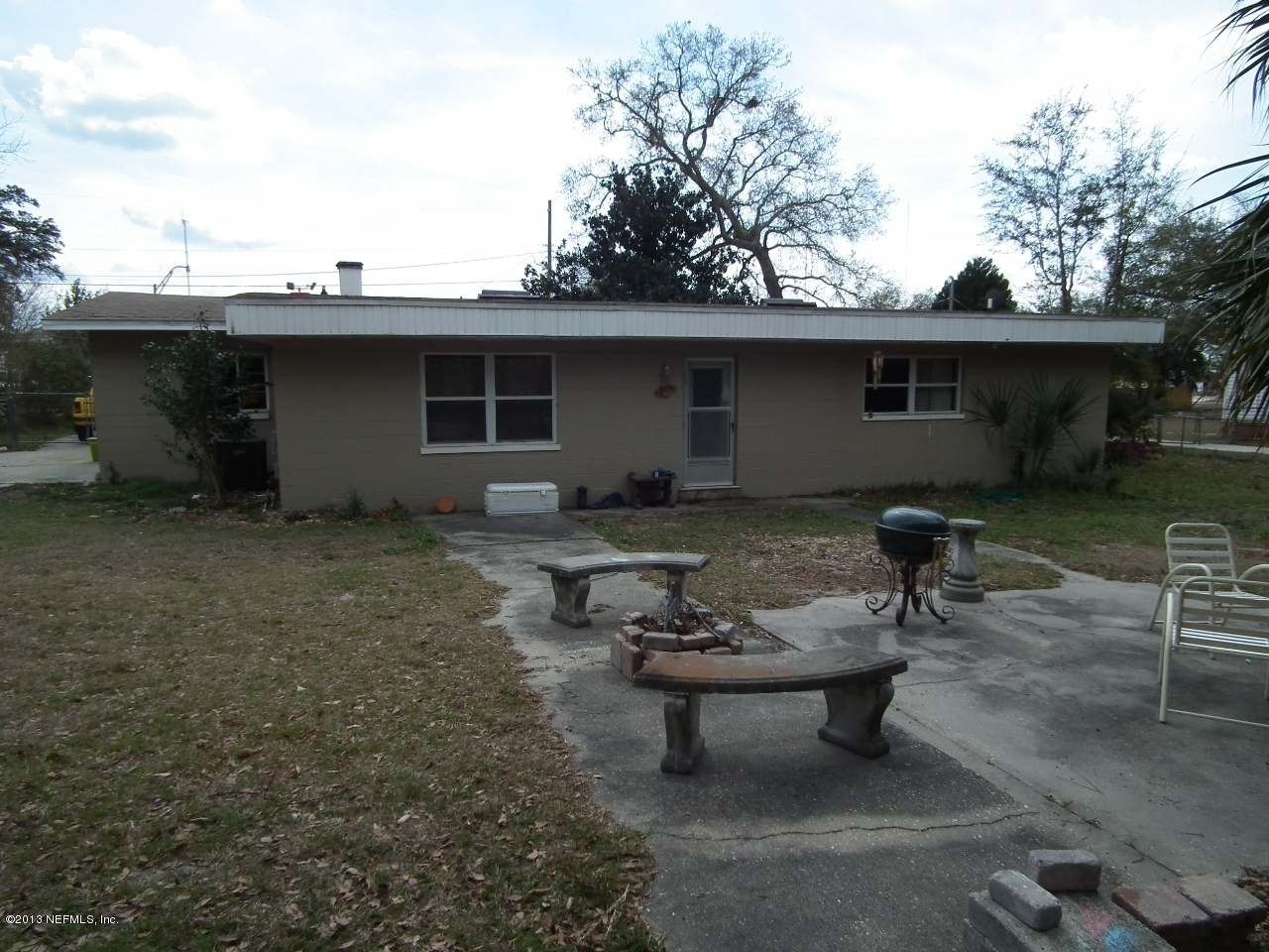 9757 Patton Road Jacksonville, FL 32246 - Photo 3 of 6 a view of a backyard with table and chairs couches under an umbrella