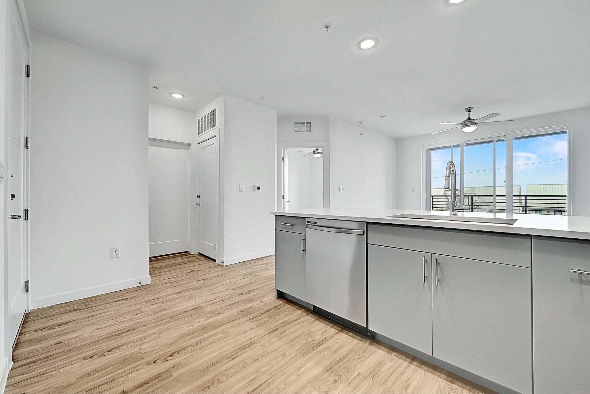 4801 Springdale Road, Unit 1301 Austin, TX 78723 - Photo 8 of 39 Modern kitchen with sleek cabinetry and durable flooring opens to a naturally illuminated living space.