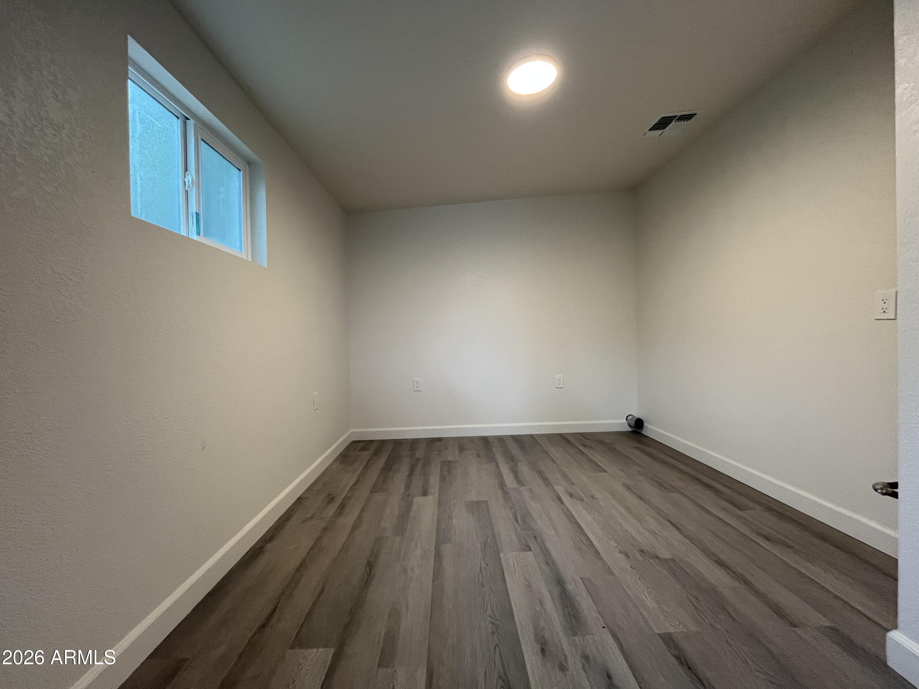 1226 South Roosevelt Street Tempe, AZ 85281 - Photo 14 of 26 a view of an empty room with wooden floor and a window