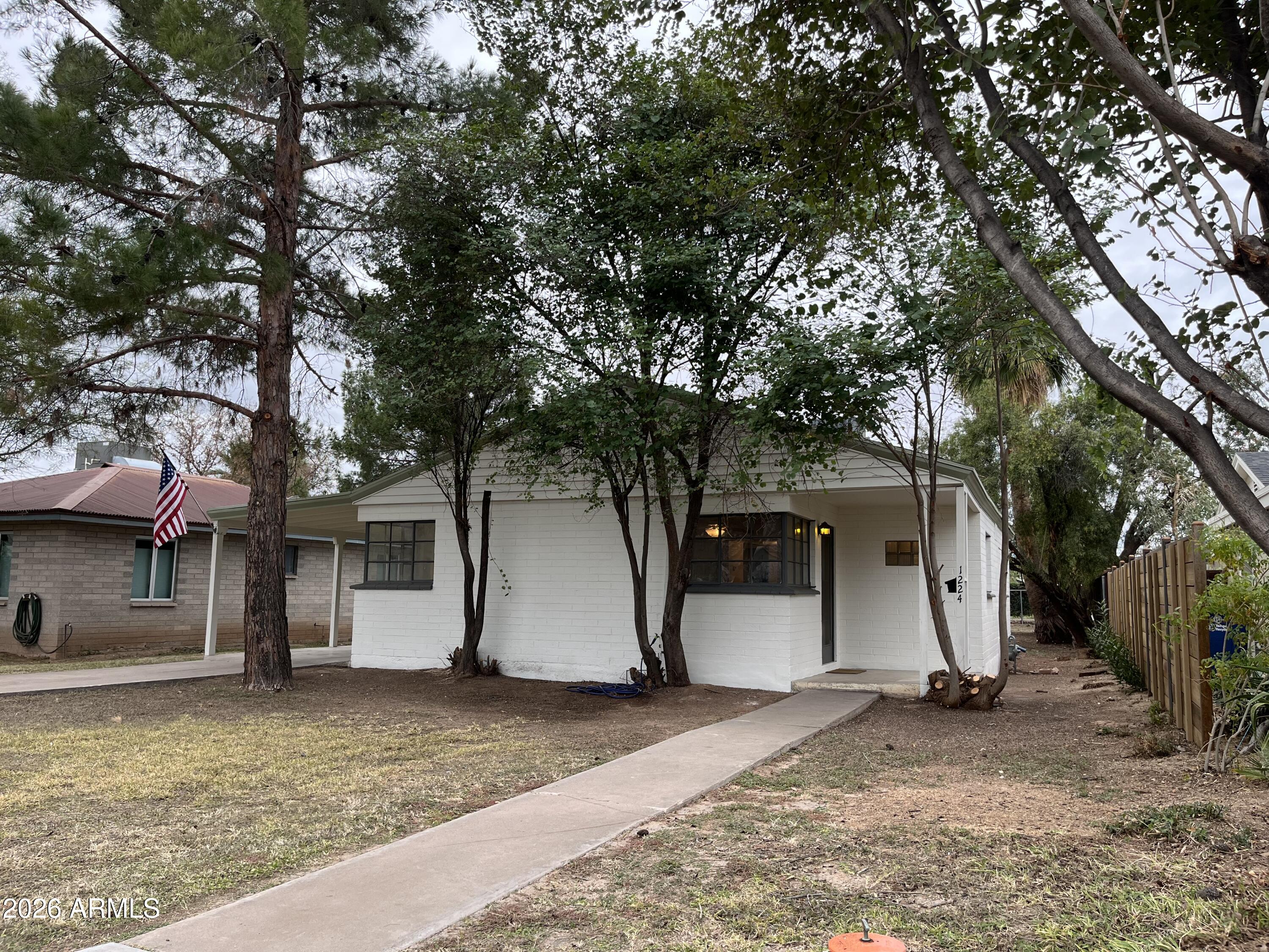 1226 South Roosevelt Street Tempe, AZ 85281 - Photo 2 of 26 a view of a white house with large tree and wooden fence