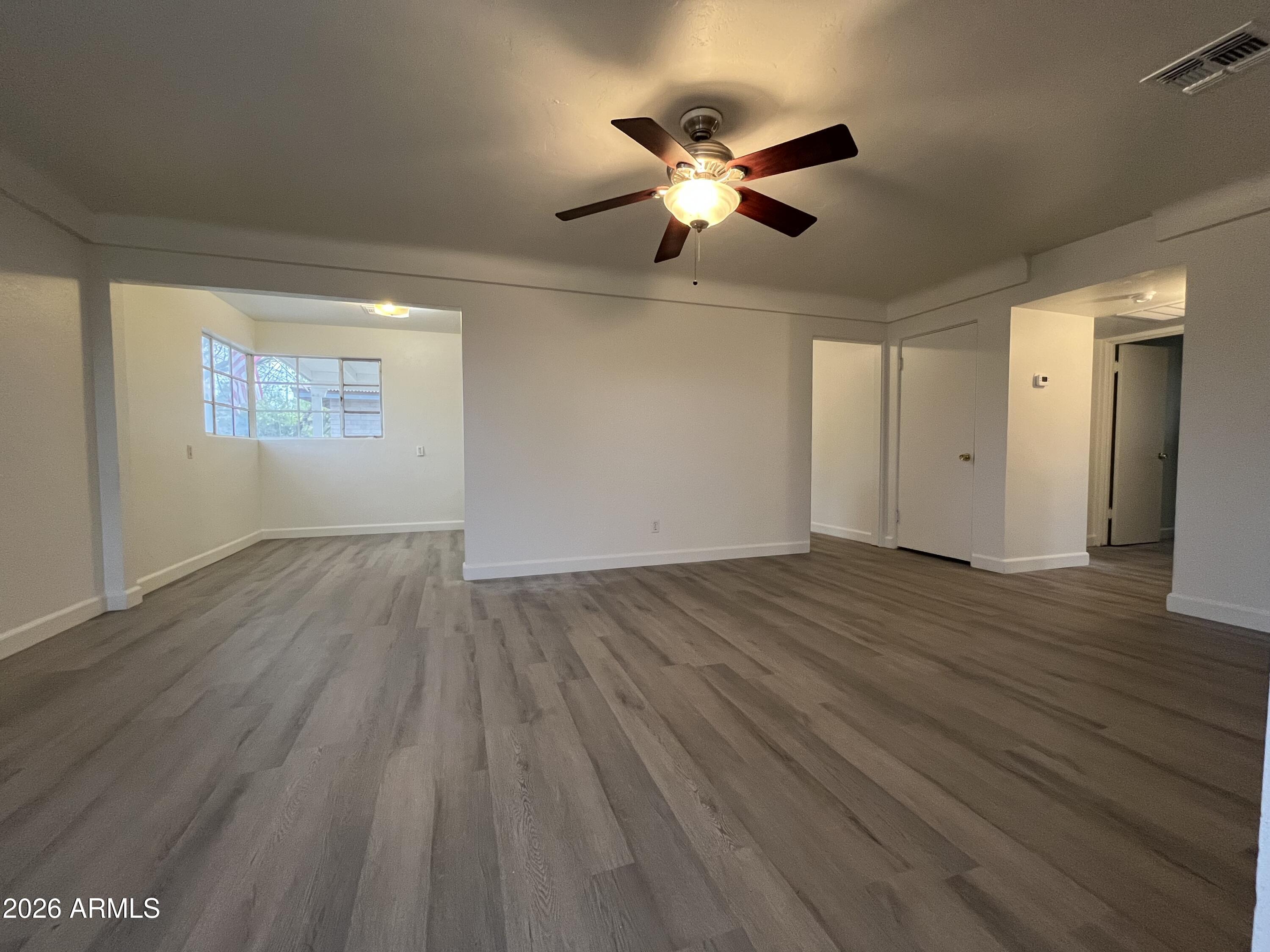 1226 South Roosevelt Street Tempe, AZ 85281 - Photo 4 of 26 a view of an empty room with wooden floor and a window
