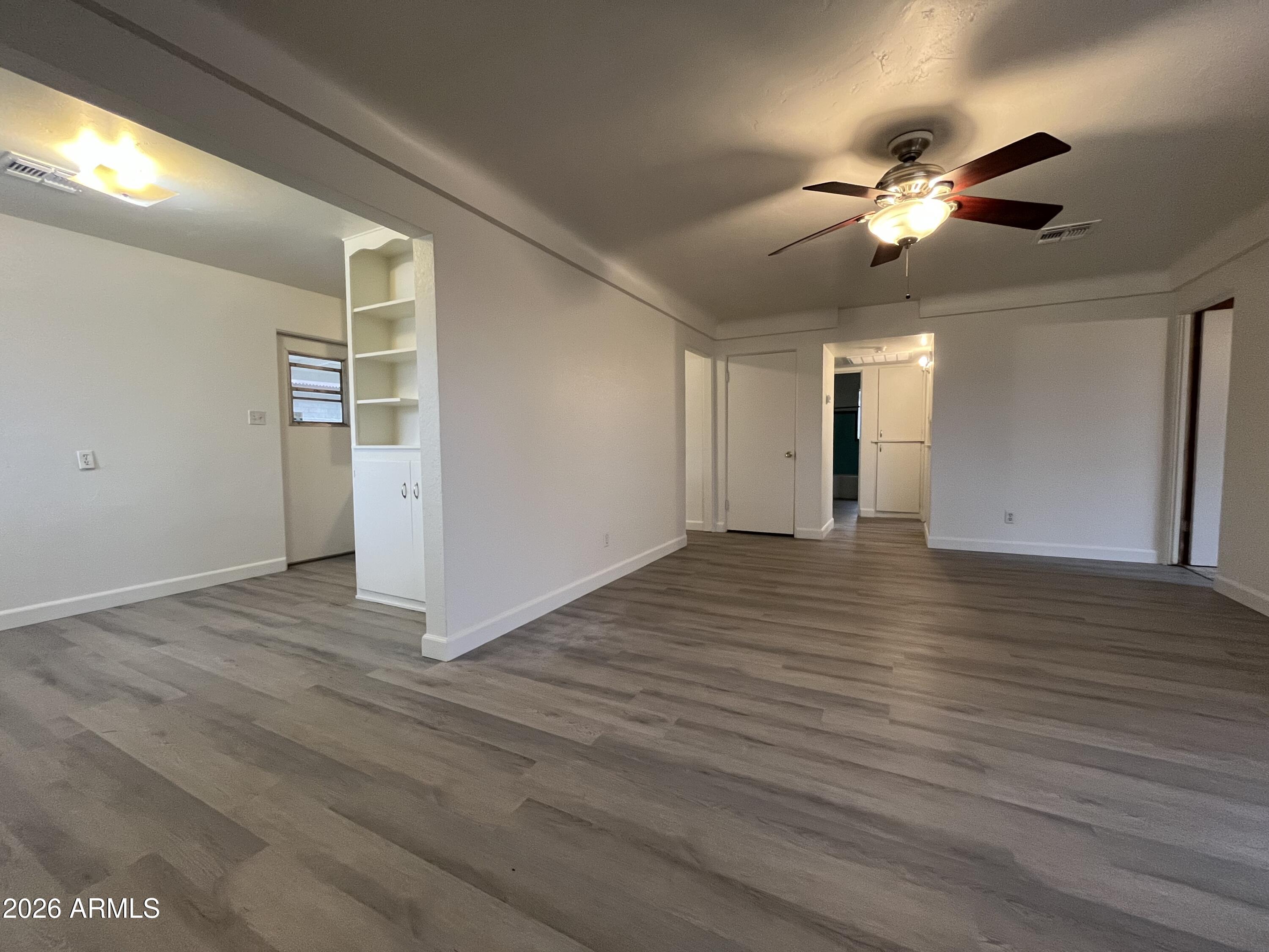 1226 South Roosevelt Street Tempe, AZ 85281 - Photo 5 of 26 a view of an empty room with wooden floor and a window