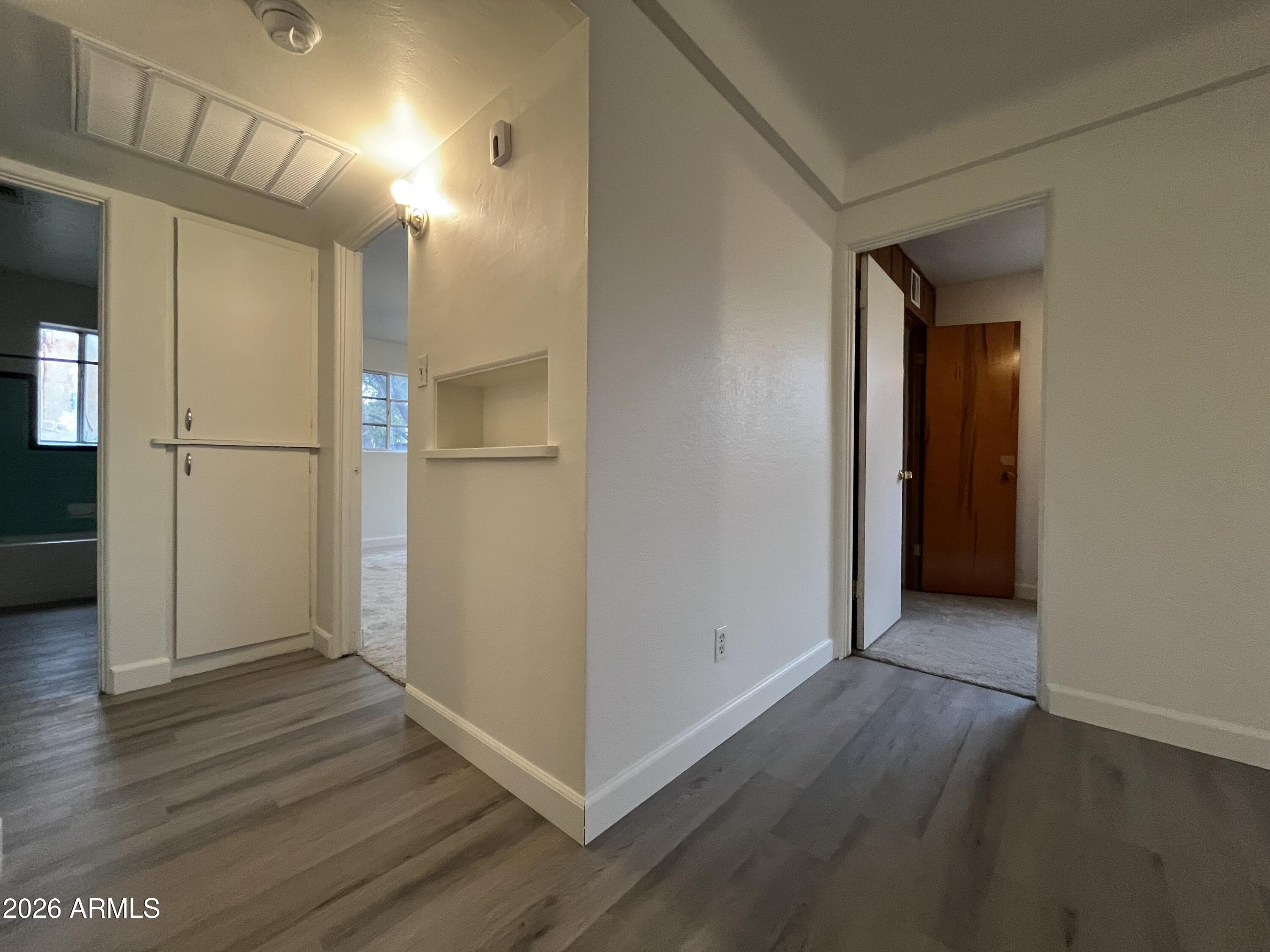 1226 South Roosevelt Street Tempe, AZ 85281 - Photo 9 of 26 a view of an empty room with wooden floor and a kitchen