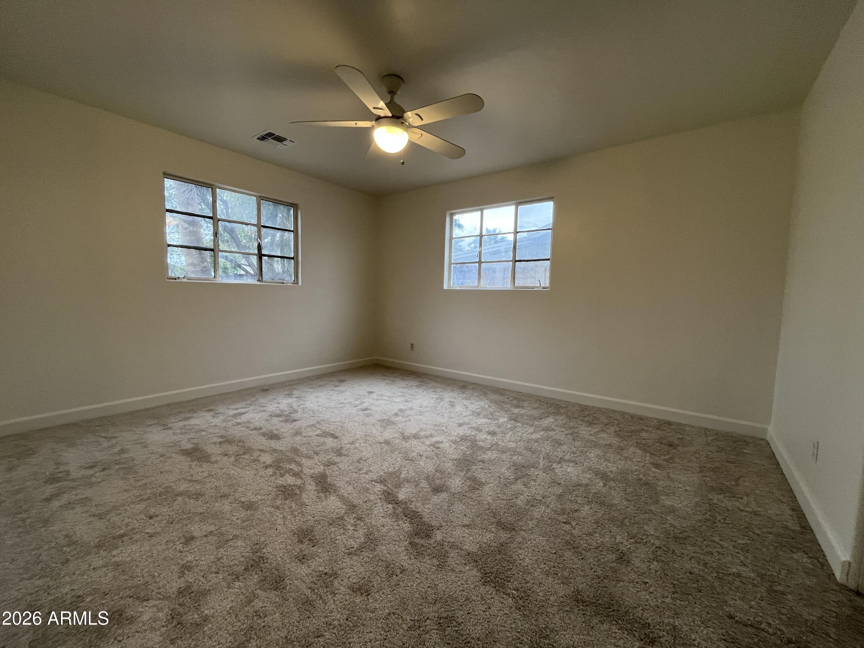1226 South Roosevelt Street Tempe, AZ 85281 - Photo 10 of 26 an empty room with a chandelier fan and windows