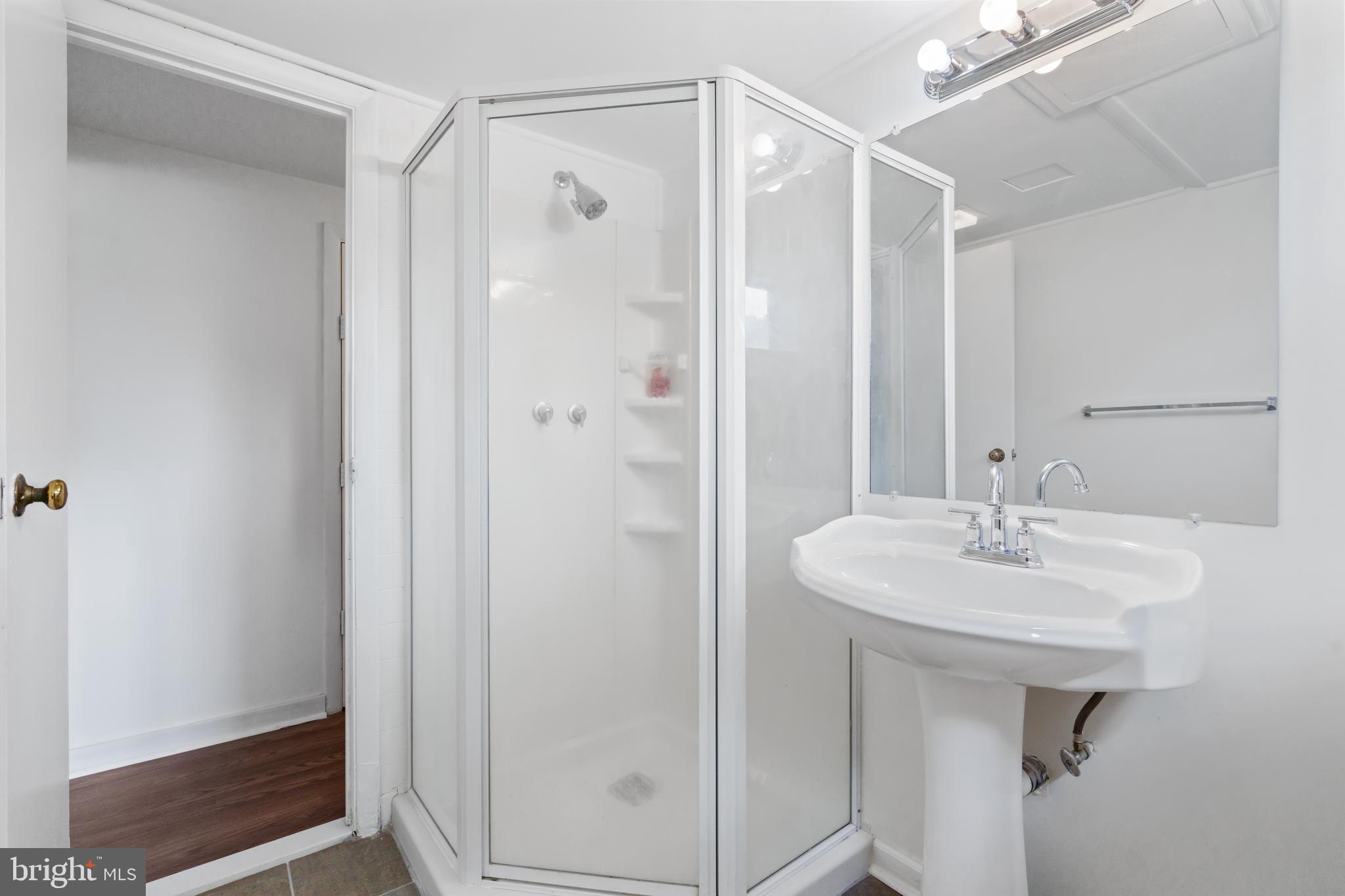 10204 Rodgers Road Fairfax, VA 22030 - Photo 22 of 29 a bathroom with a sink a mirror and a shower