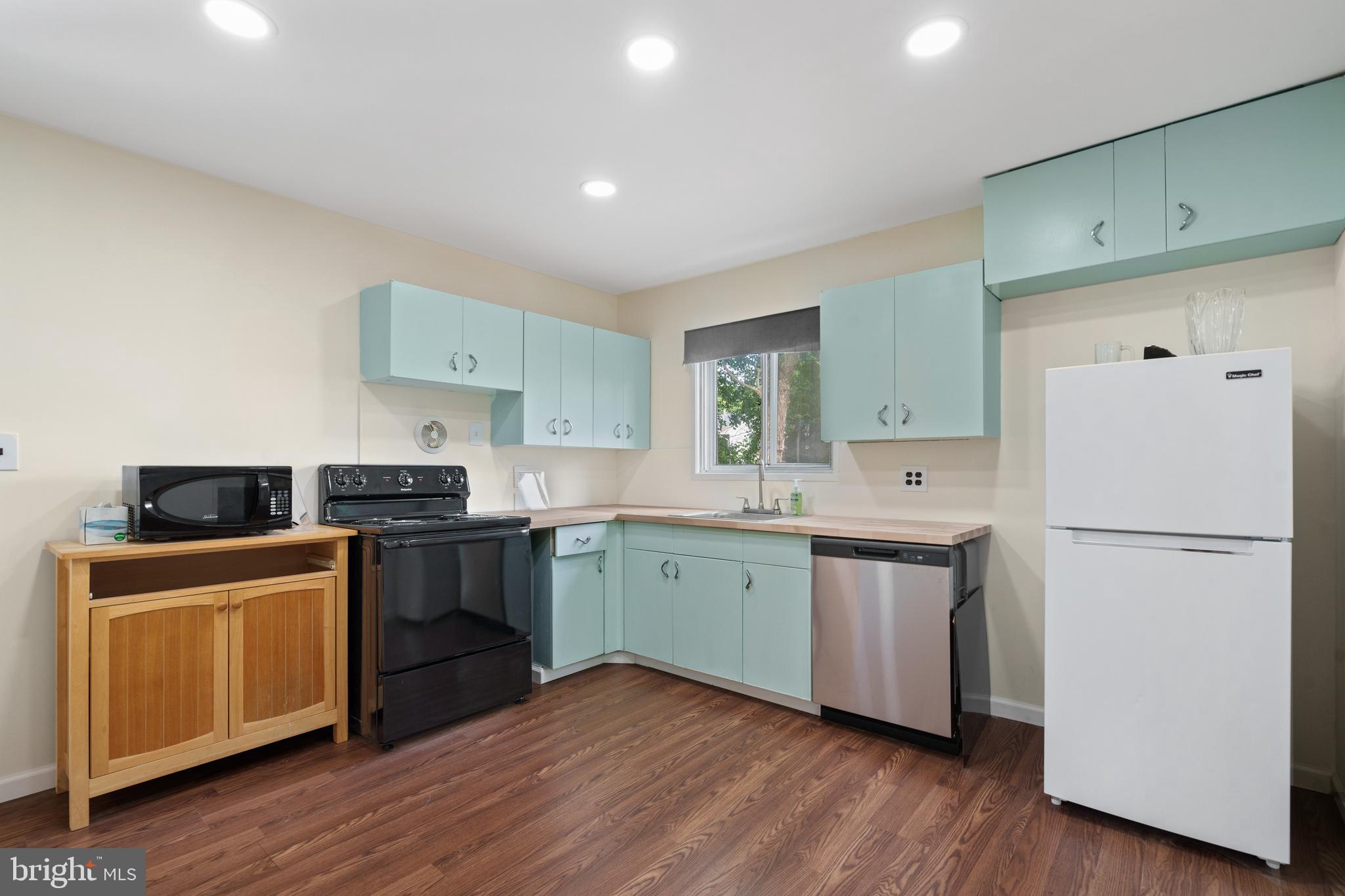 10204 Rodgers Road Fairfax, VA 22030 - Photo 7 of 29 a kitchen with a white cabinets a sink dishwasher and a refrigerator with wooden floor