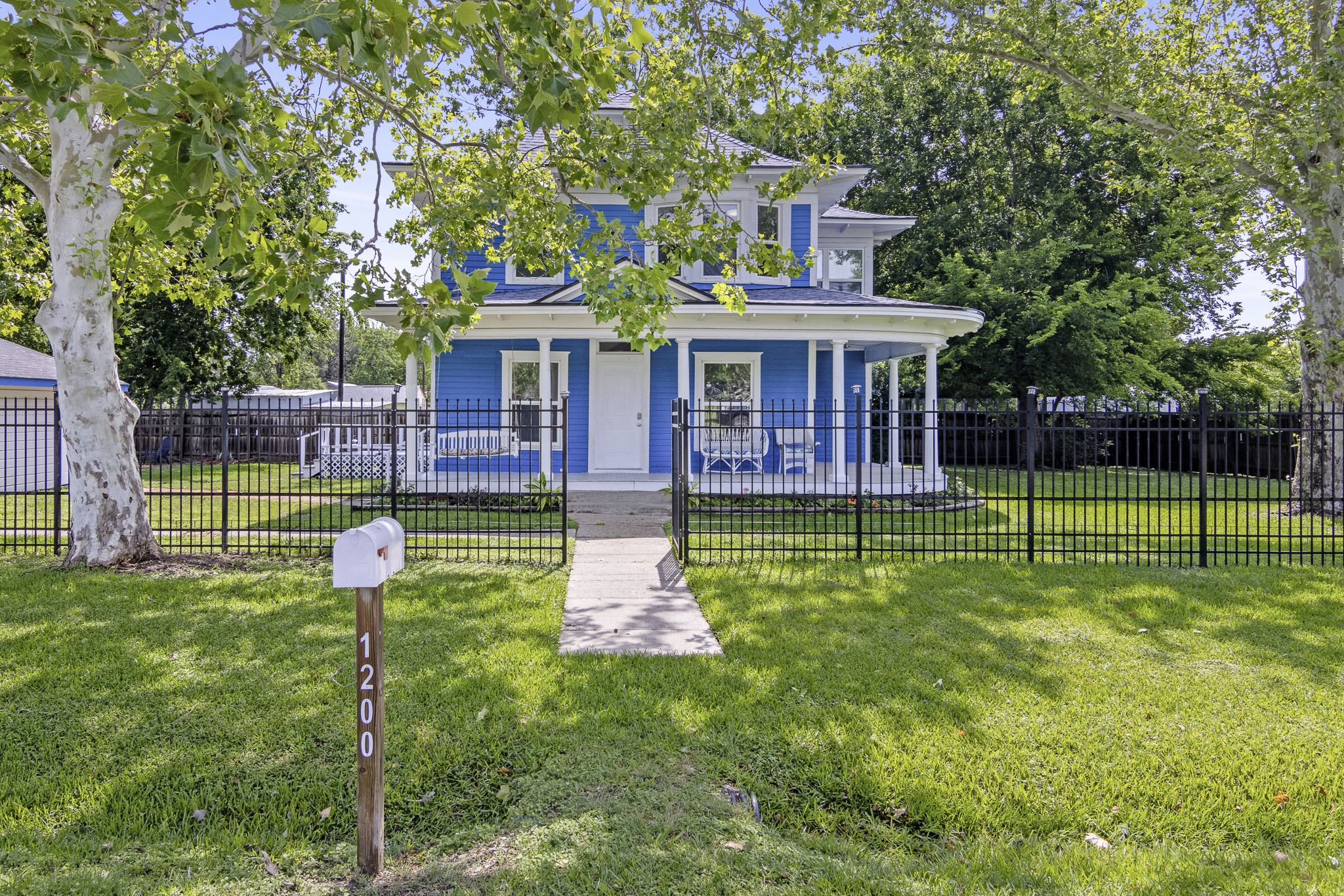 a view of a house with a backyard and a large tree