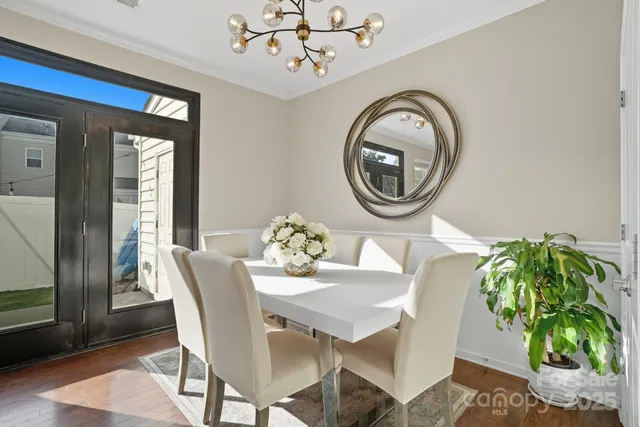 a living room with stainless steel appliances furniture a dining table and kitchen view