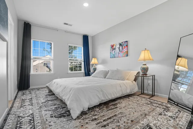 a bedroom with a bed and a lamp on dresser