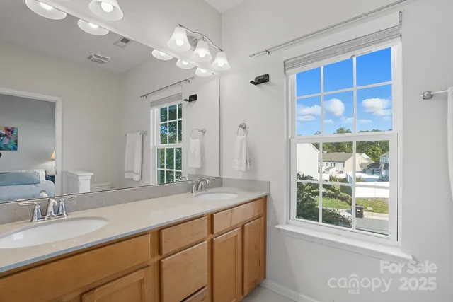 a bathroom with a granite countertop sink a mirror and a shower
