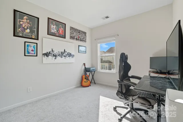 a view of a workspace with furniture and a window