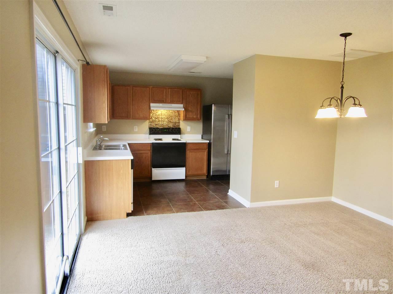 7420 Lowell Ridge Road Raleigh, NC 27616 - Photo 6 of 21 a kitchen with stainless steel appliances granite countertop a refrigerator a oven a sink with a dining table and chairs