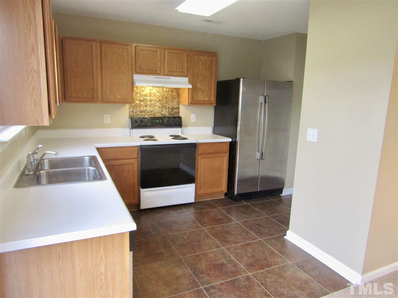 7420 Lowell Ridge Road Raleigh, NC 27616 - Photo 7 of 21 a kitchen with stainless steel appliances a stove a refrigerator and a sink