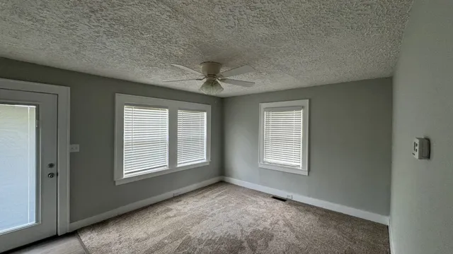 an empty room with windows and closet