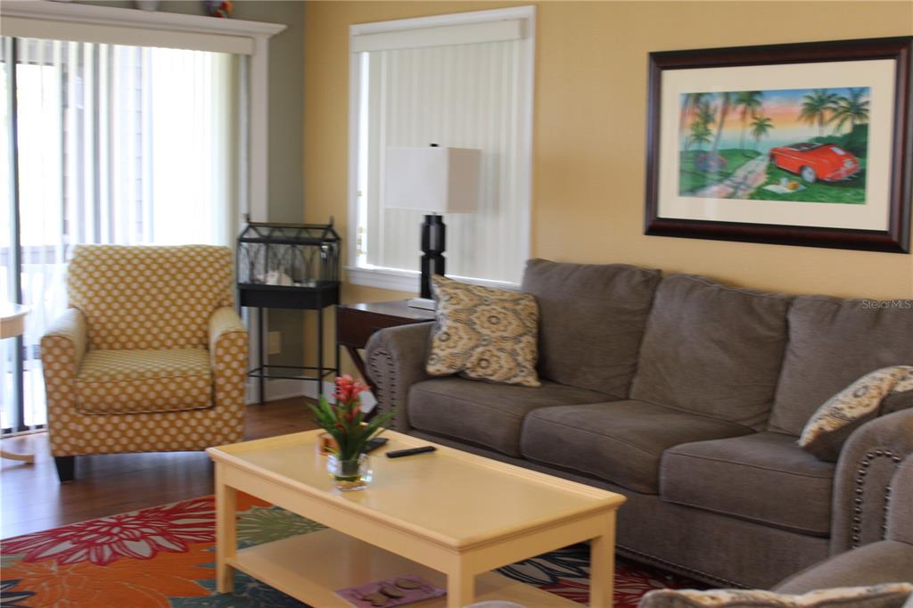 335 Windrush Loop, Unit 335 Tarpon Springs, FL 34689 - Photo 5 of 18 a living room with furniture a couch and a large window