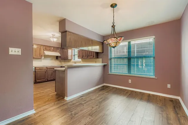 a kitchen with kitchen island granite countertop a sink cabinets and wooden floor