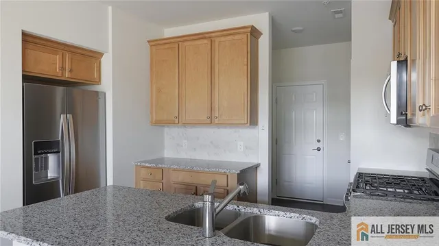 a kitchen with stainless steel appliances granite countertop a refrigerator and a sink