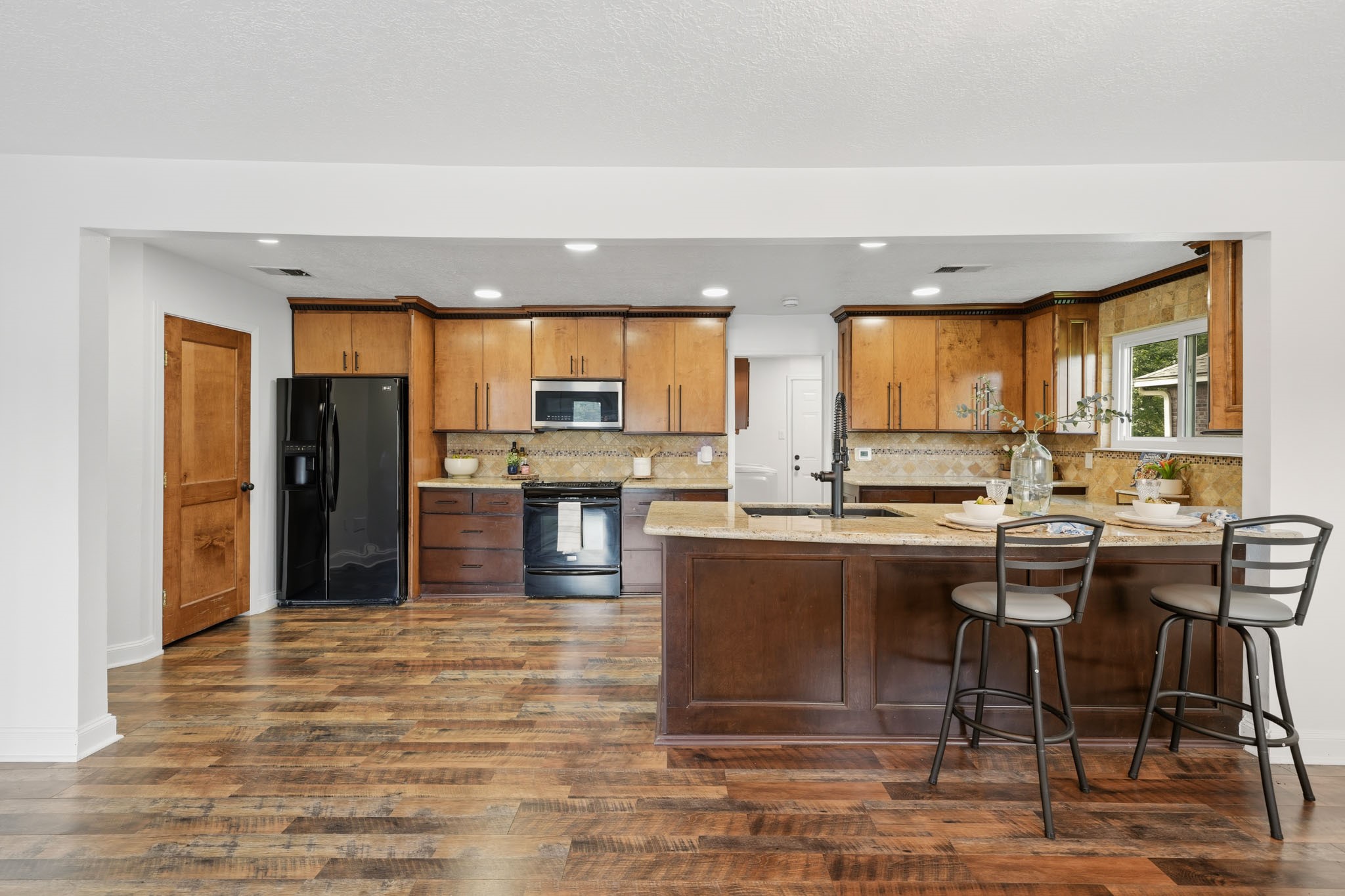 79 Summers Wind Street Conroe, TX 77356 - Photo 12 of 45 a kitchen with stainless steel appliances granite countertop a stove top oven a refrigerator a sink and a dining table view