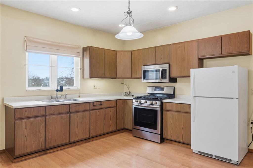 373 Copperfield Avenue Pittsburgh, PA 15210 - Photo 14 of 39 a kitchen with stainless steel appliances granite countertop a stove a sink dishwasher a refrigerator and a microwave oven with wooden floor