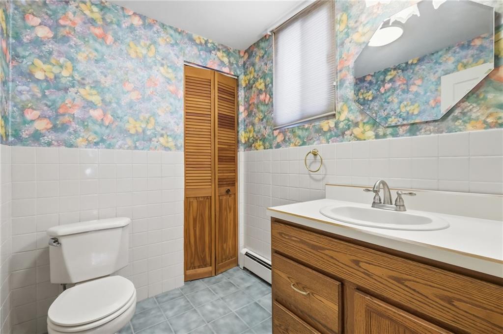 373 Copperfield Avenue Pittsburgh, PA 15210 - Photo 16 of 39 a bathroom with a sink a toilet and a mirror