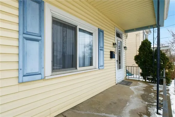 a view of a house with a door and wooden bench