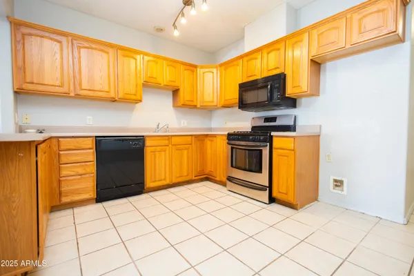 a kitchen with stainless steel appliances granite countertop a stove a sink and a microwave