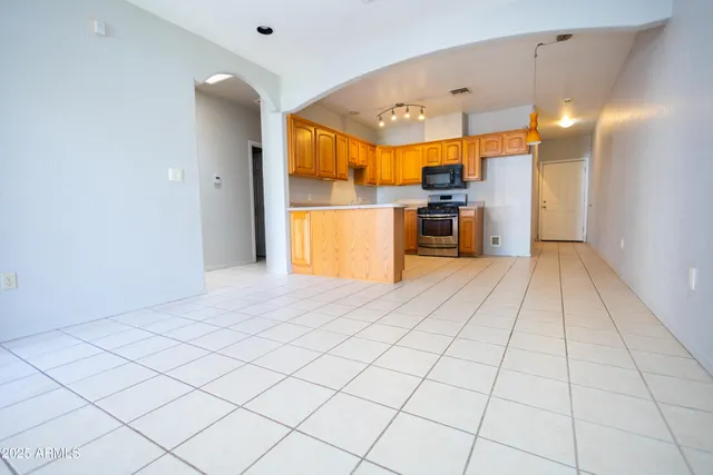 a view of a kitchen with a sink and an empty room