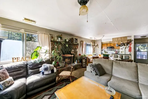 a living room with furniture fireplace and a large window