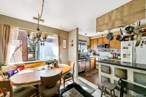 a kitchen with stainless steel appliances granite countertop a sink a stove and chairs