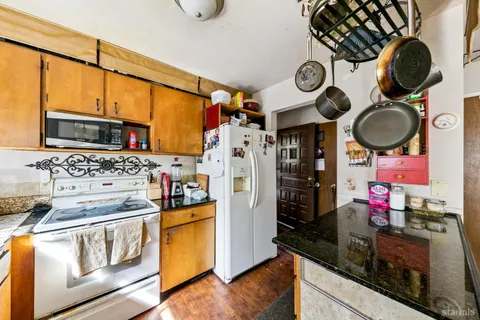 a kitchen with stainless steel appliances granite countertop a stove a refrigerator and a microwave