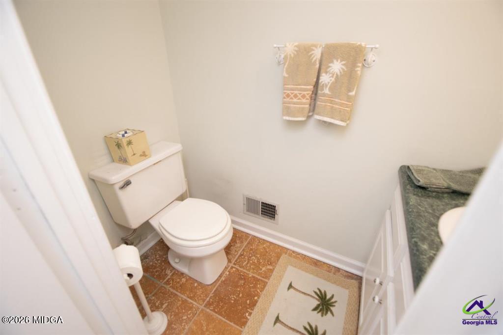 1441 Zenith Mill Road Roberta, GA 31078 - Photo 71 of 80 a white toilet sitting next to a white sink and vanity