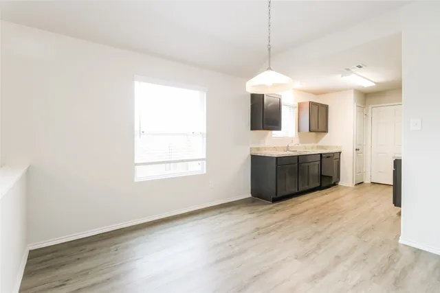 a view of a kitchen with a sink a fireplace and wooden floor