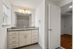 8 Dustin Street, Unit 103 Boston, MA 02135 - Photo 6 of 10 a bathroom with a granite countertop sink and a mirror