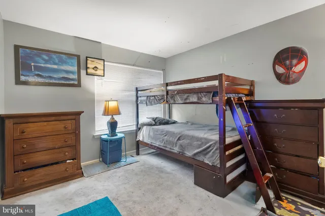 a bedroom with a bed and a lamp on dresser