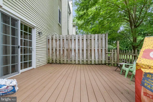 a view of a backyard with wooden floor and fence