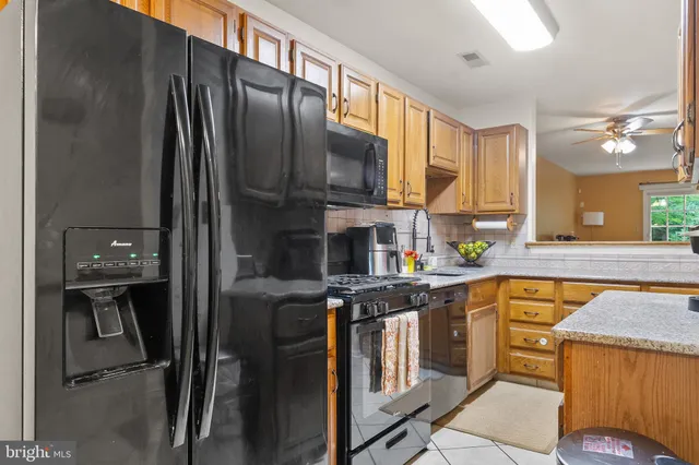 a kitchen with stainless steel appliances granite countertop a refrigerator a stove and a sink