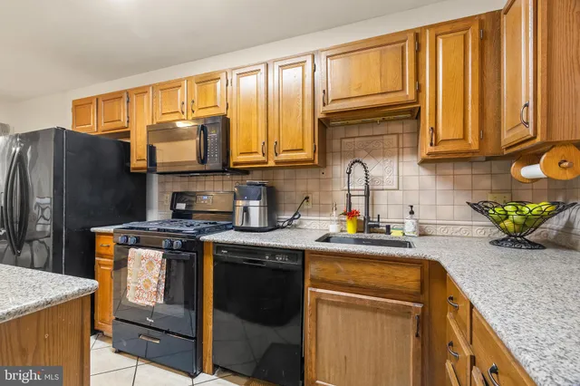 a kitchen with stainless steel appliances granite countertop a stove a sink dishwasher and microwave with cabinets