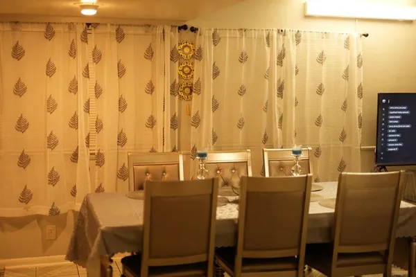 a dining room with furniture and a curtain