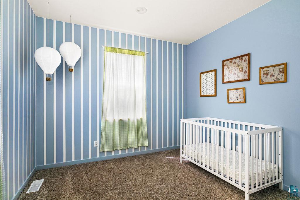 1825 East Shilhon Road Duluth, MN 55804 - Photo 31 of 37 Room with striped accent wall, recessed ceiling lighting, and carpeted flooring.