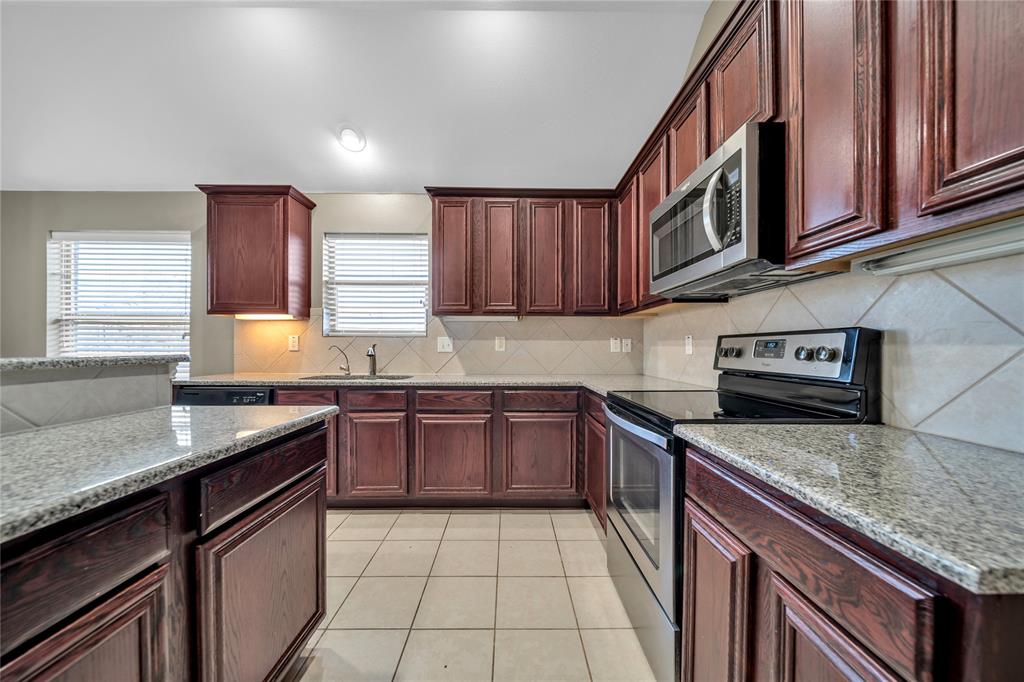 263 Archer Way Forney, TX 75126 - Photo 11 of 23 a kitchen with stainless steel appliances granite countertop a sink stove and cabinets