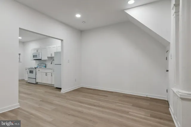 a view of a kitchen with white cabinets and wooden floor