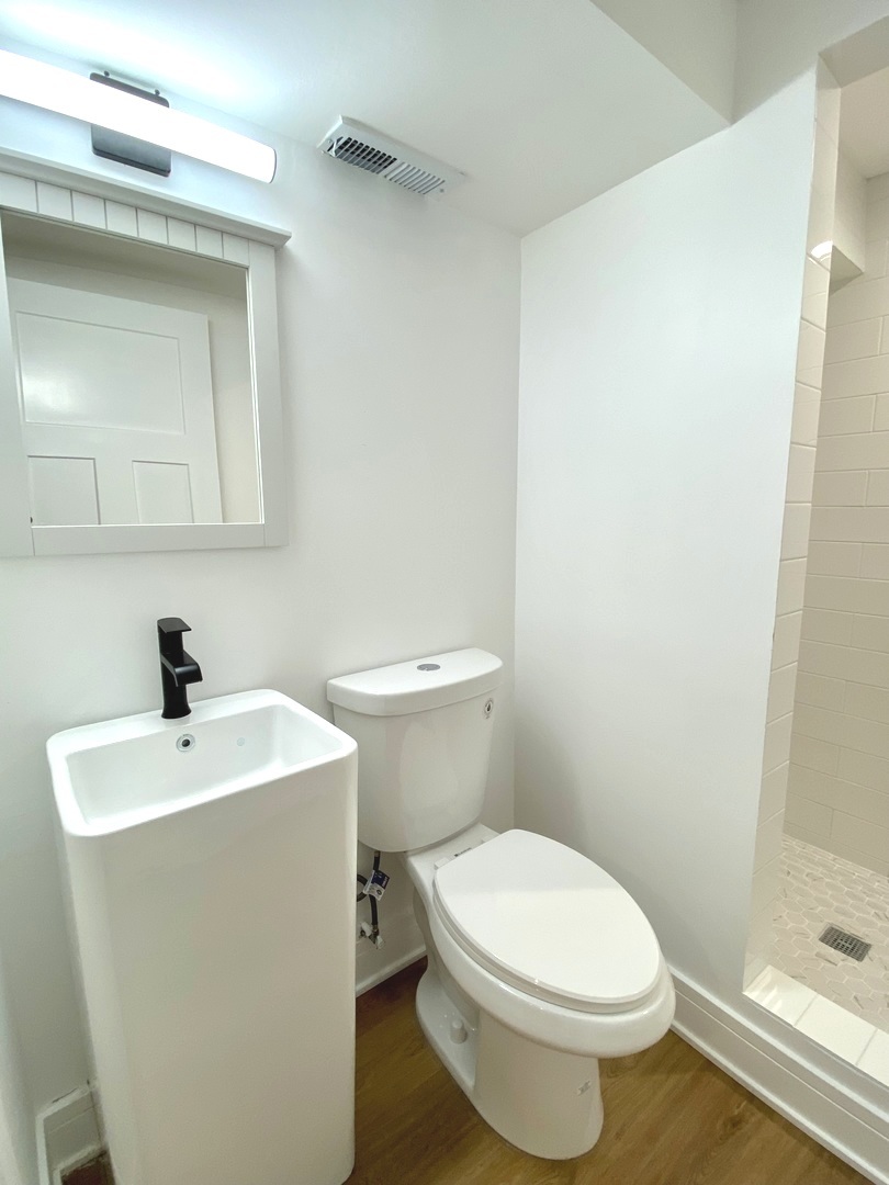 Undisclosed Address Chicago, IL 60617 - Photo 27 of 29 a white toilet sitting next to a bathroom sink