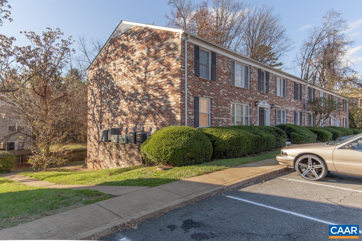 2527 Hydraulic Road, Unit 51 Charlottesville, VA 22901 - Photo 17 of 18 a view of a car parked in front of a brick house with a yard
