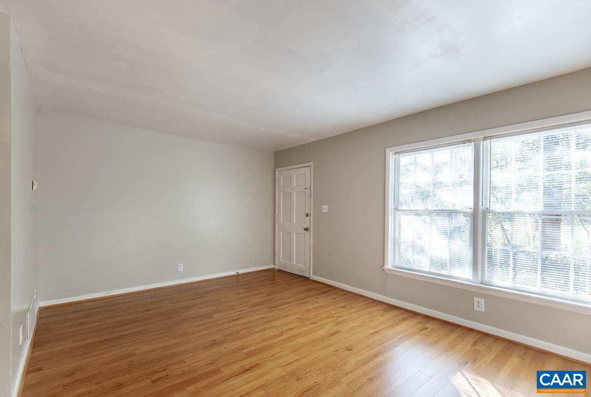 2527 Hydraulic Road, Unit 51 Charlottesville, VA 22901 - Photo 2 of 18 a view of empty room with wooden floor and fan