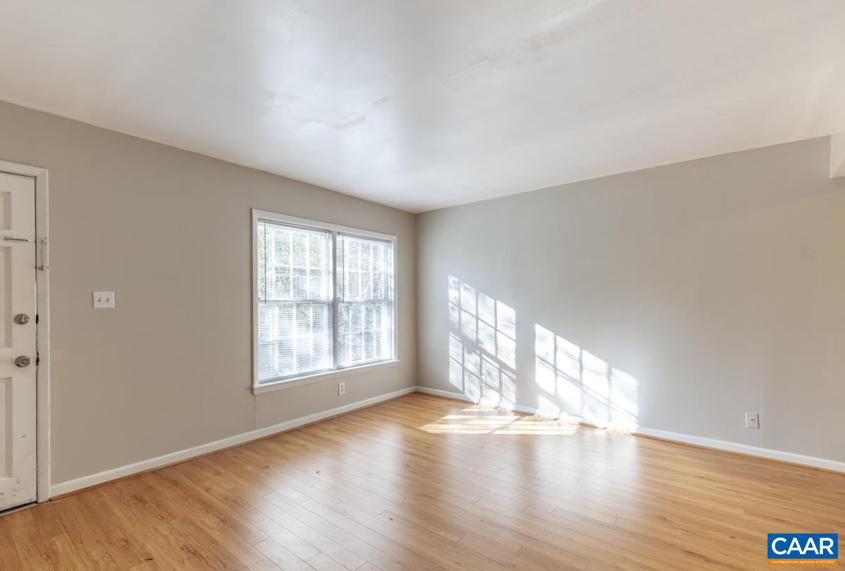 2527 Hydraulic Road, Unit 51 Charlottesville, VA 22901 - Photo 3 of 18 a view of an empty room with wooden floor and a window