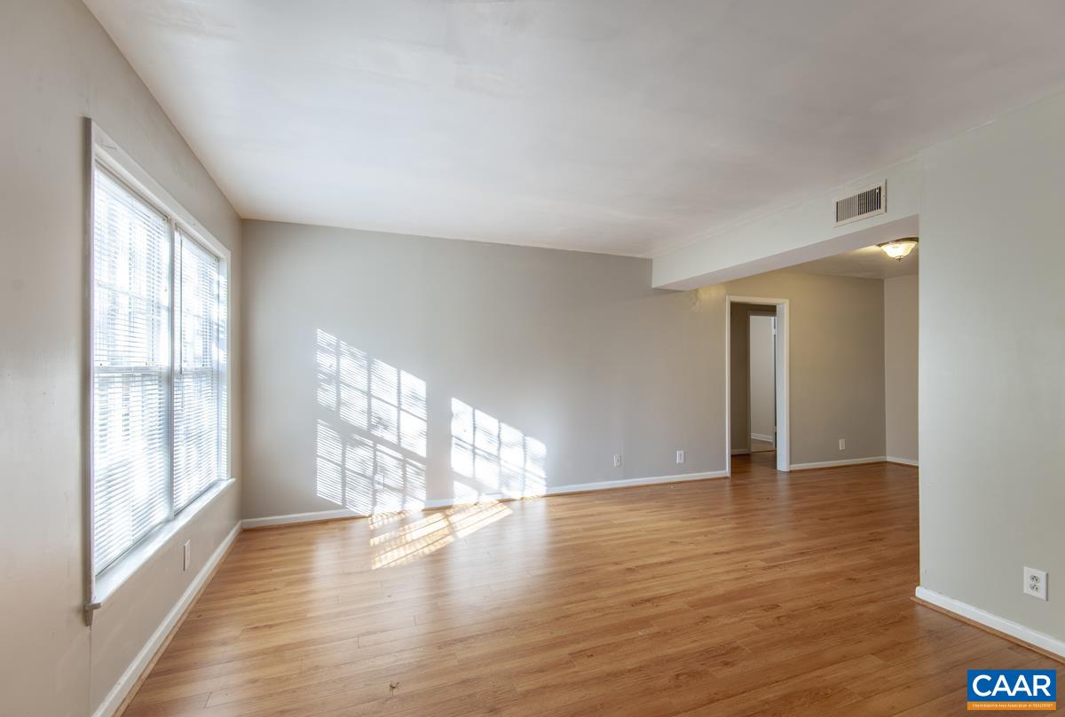 2527 Hydraulic Road, Unit 51 Charlottesville, VA 22901 - Photo 4 of 18 a view of an empty room with wooden floor and a window