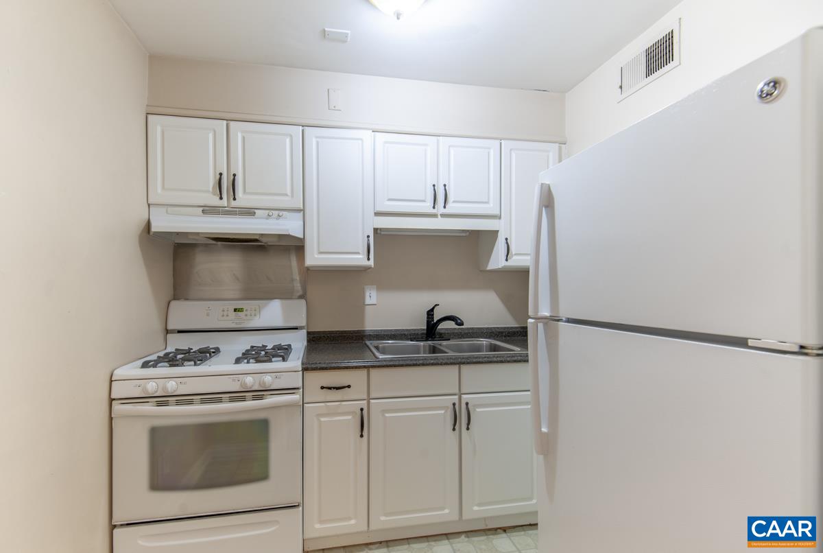2527 Hydraulic Road, Unit 51 Charlottesville, VA 22901 - Photo 8 of 18 a kitchen with stainless steel appliances white cabinets and a refrigerator