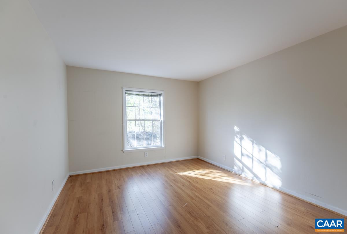 2527 Hydraulic Road, Unit 51 Charlottesville, VA 22901 - Photo 10 of 18 an empty room with wooden floor and windows
