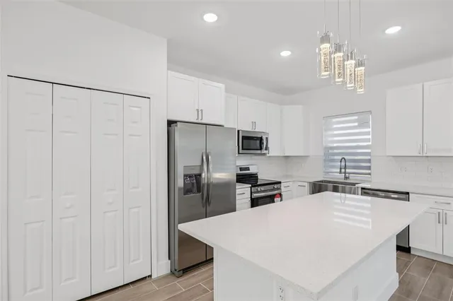 a kitchen with stainless steel appliances a refrigerator sink and microwave