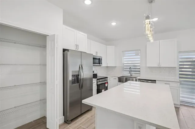 a kitchen with a refrigerator a sink and cabinets